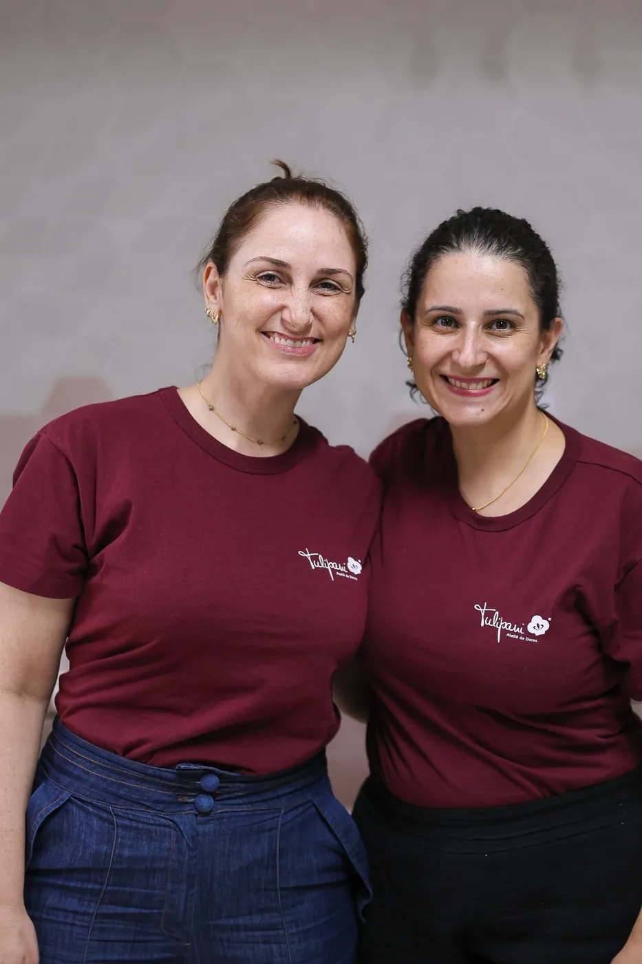 Amanda Ferraz e Lidiane Candido, sócias da Tulipani, lado a lado com o uniforme da marca